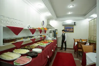 a man standing in front of a buffet line with food at Sirkeci Emek Hotel in Istanbul