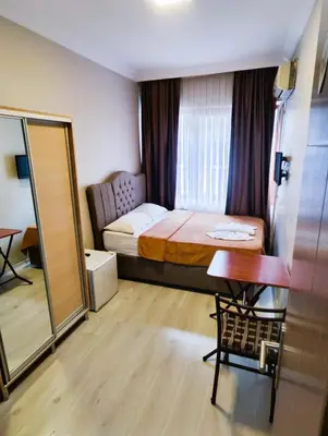 a bedroom with a bed and a table and a mirror at Birol Hotel in Istanbul