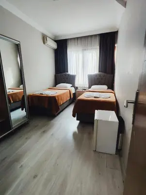 a hotel room with two beds and a mirror at Birol Hotel in Istanbul