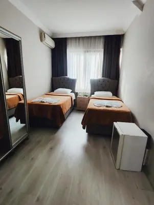 a hotel room with two beds and a mirror at Birol Hotel in Istanbul