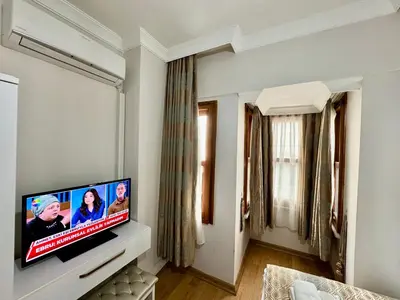 a living room with a flat screen tv on a wall at Rosalie Palace Hotel in Istanbul