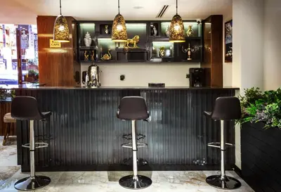 a bar with three stools in front of a counter at Endican Beyazit Hotel in Istanbul