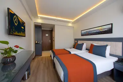 a hotel room with two beds and a desk at Hotel Eyfel in Istanbul