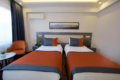 a hotel room with two beds and a table at Hotel Eyfel in Istanbul