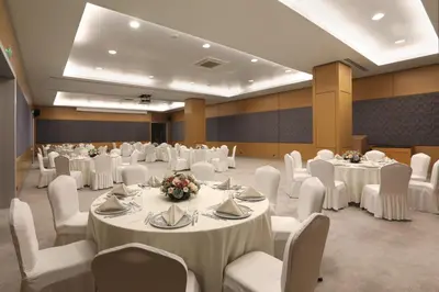 a banquet hall with white tables and white chairs at Divan Corlu in Corlu