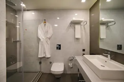 a bathroom with a white robe hanging on the wall at Divan Corlu in Corlu