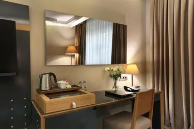 a desk in a hotel room with a mirror at Divan Corlu in Corlu