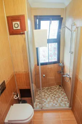 a bathroom with a shower with a toilet and a window at Esans Hotel - Special Category in Istanbul