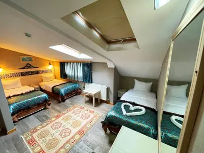 a hotel room with two beds and a couch at Hotel Novano in Istanbul