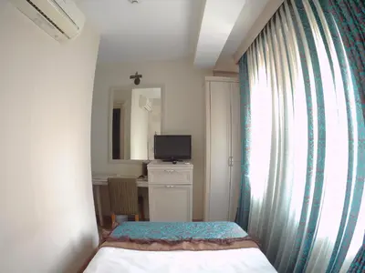 a bedroom with a bed and a desk and a window at Hotel Novano in Istanbul