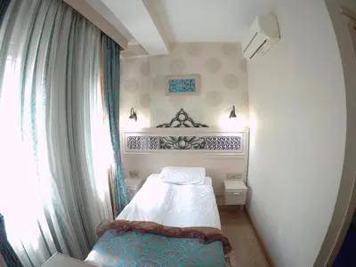 a small bedroom with a bed and a window at Hotel Novano in Istanbul