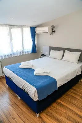 a bedroom with a large bed with a blue blanket at Asitane Life Hotel in Istanbul