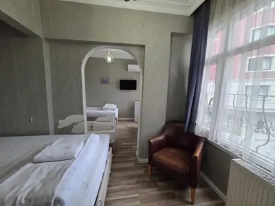 a bedroom with two beds and a mirror and a chair at Asitane Life Hotel in Istanbul