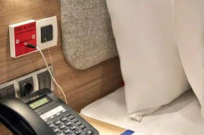 a phone plugged into an electrical outlet next to a bed at Holiday Inn Express - Istanbul - Atakoy Metro by IHG in Istanbul