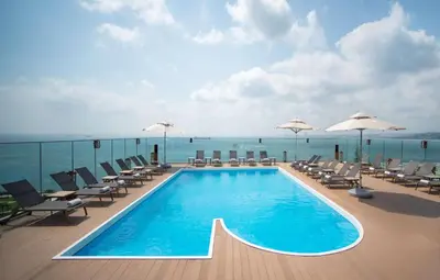 a swimming pool on a deck with chairs and umbrellas at DoubleTree By Hilton Istanbul - Moda in Istanbul
