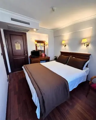 a hotel room with a large bed and a television at Emine Sultan Hotel in Istanbul
