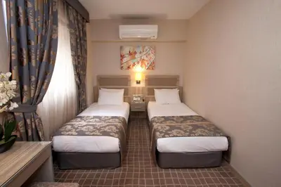 a hotel room with two beds and a window at Nanda Hotel in Istanbul