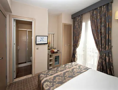 a bedroom with a bed and a window with a television at Nanda Hotel in Istanbul