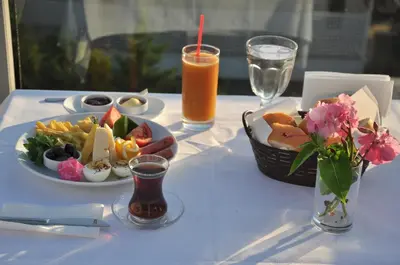 a white table with a plate of food and a drink at dragos island hotel in Istanbul