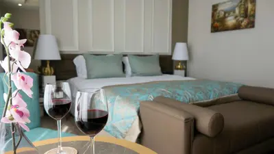 a bedroom with a bed and two glasses of wine at The Escape Hotel in Agva