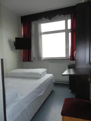 a bedroom with a bed and a window and a television at Cagri Hotel in Istanbul