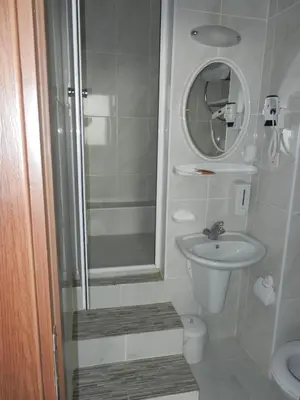 a bathroom with a shower and a sink and a mirror at Cagri Hotel in Istanbul