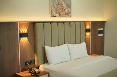 a bedroom with a bed and a phone on a table at Lion City Hotel Bursa in Bursa