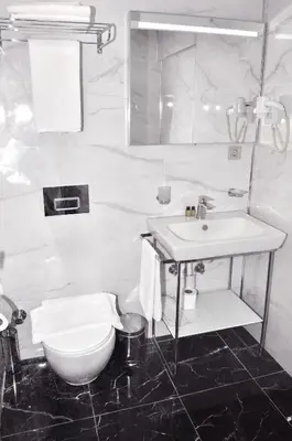a white bathroom with a sink and a toilet at Hotel Davos Istanbul in Istanbul