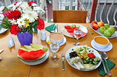 a wooden table topped with plates of food and fruit at Hotel Davos Istanbul in Istanbul