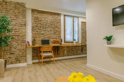 a room with a desk with a computer on a brick wall at The Wilson Galata Hotel in Istanbul