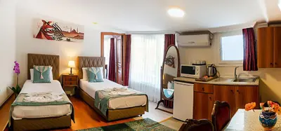 a small room with two beds and a kitchen at Sultan House in Istanbul
