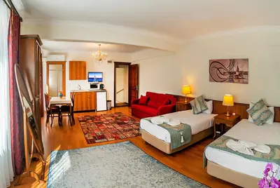 a living room with two beds and a red couch at Sultan House in Istanbul