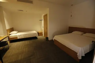 a hotel room with two beds and a desk at Pera Hotel Lüleburgaz in Lüleburgaz