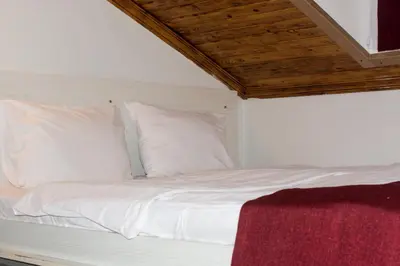 a bed with white sheets and pillows in a room at Hot Budget Ortakoy in Istanbul