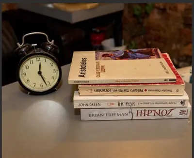 a stack of books and an alarm clock on a table at Hot Budget Ortakoy in Istanbul