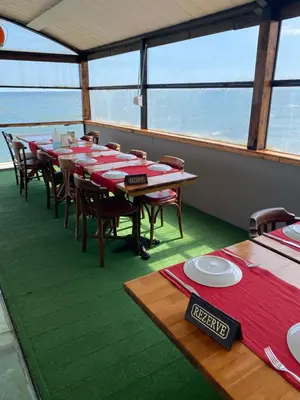 a dining room on a boat with tables and chairs at Odrys Beach Hotel & Resort in Tekirdag