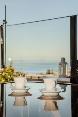 two cups on a glass table with a view of the ocean at Sultanahmet Cesme Hotel in Istanbul
