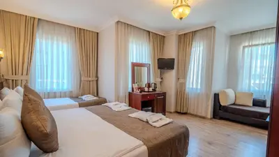 a hotel room with a large bed and a couch at Sultanahmet Cesme Hotel in Istanbul