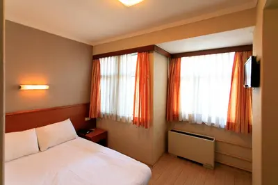 a bedroom with a bed and two windows at Hotel Inter Istanbul in Istanbul