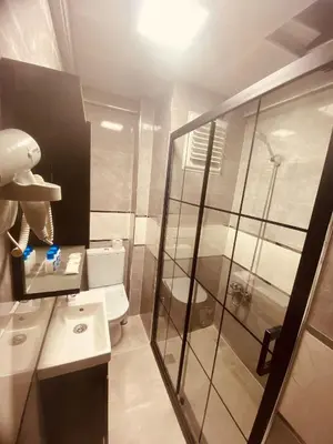 a bathroom with a toilet and a glass shower at Malkoç Hotel in Istanbul