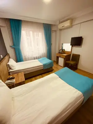 a hotel room with two beds and a television at Malkoç Hotel in Istanbul