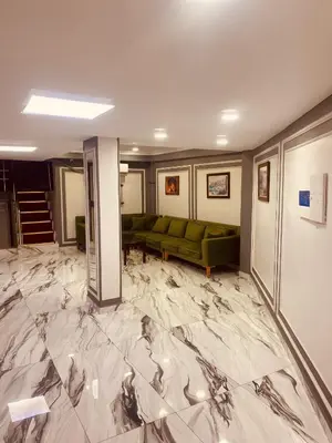 a living room with a green couch on a marble floor at Malkoç Hotel in Istanbul