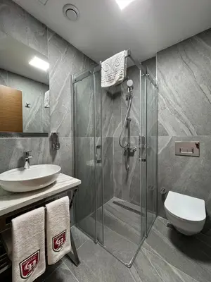 a bathroom with a shower and a toilet and a sink at Center Hill Hotel in Istanbul