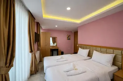 two beds in a room with pink walls at Gulhane Corner Hotel in Istanbul