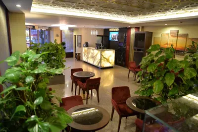 a lobby with tables and chairs and potted plants at Golden Siyav Hotel in Istanbul