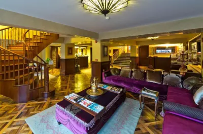 a living room with purple couches and a staircase at Sokullu Pasa Hotel - Special Class in Istanbul