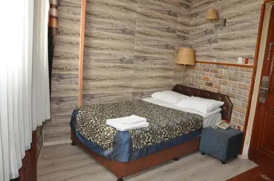a bedroom with a bed and a brick wall at Hotel Red Rose in Istanbul