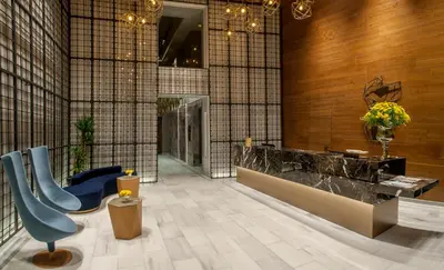a lobby with a blue chair and a counter at Somerset Maslak Istanbul in Istanbul
