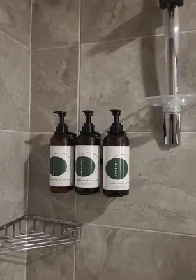 three bottles of soap sitting on a shelf in a bathroom at Somerset Maslak Istanbul in Istanbul