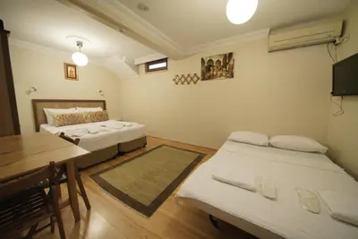 a room with two beds and a desk and a table at Topkapi Apartments in Istanbul